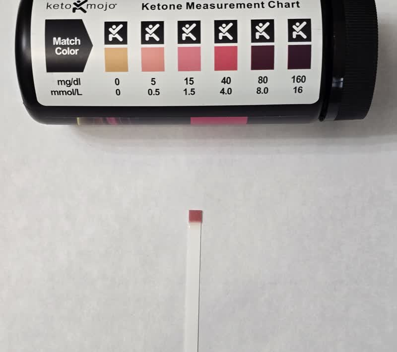 Day 31 ketone strip next to the color chart reading in the lighter range