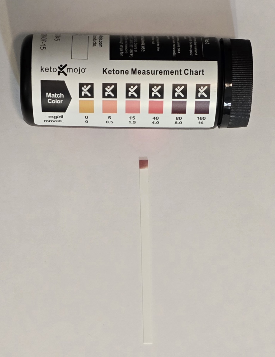 Keto Mojo ketone strip on day 6 next to the color chart